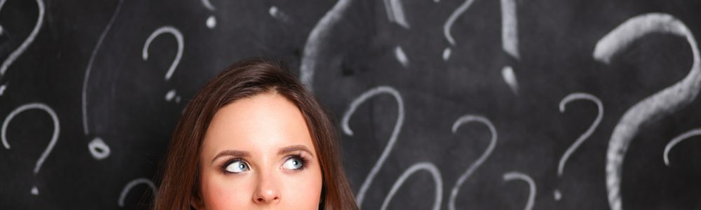 Young girl with question mark on a gray background